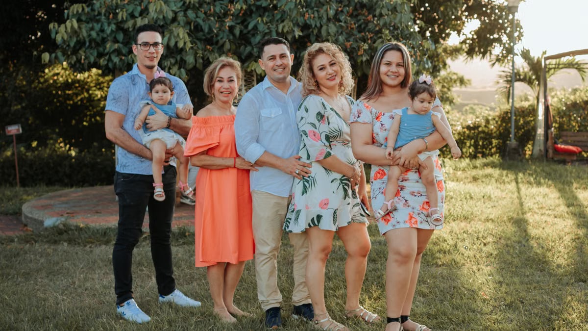 A joyful family posing together outdoors at sunset in a park.